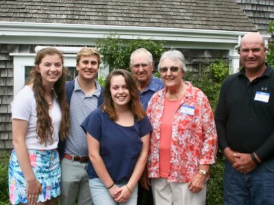 Group of six standing in front of building with nametags.