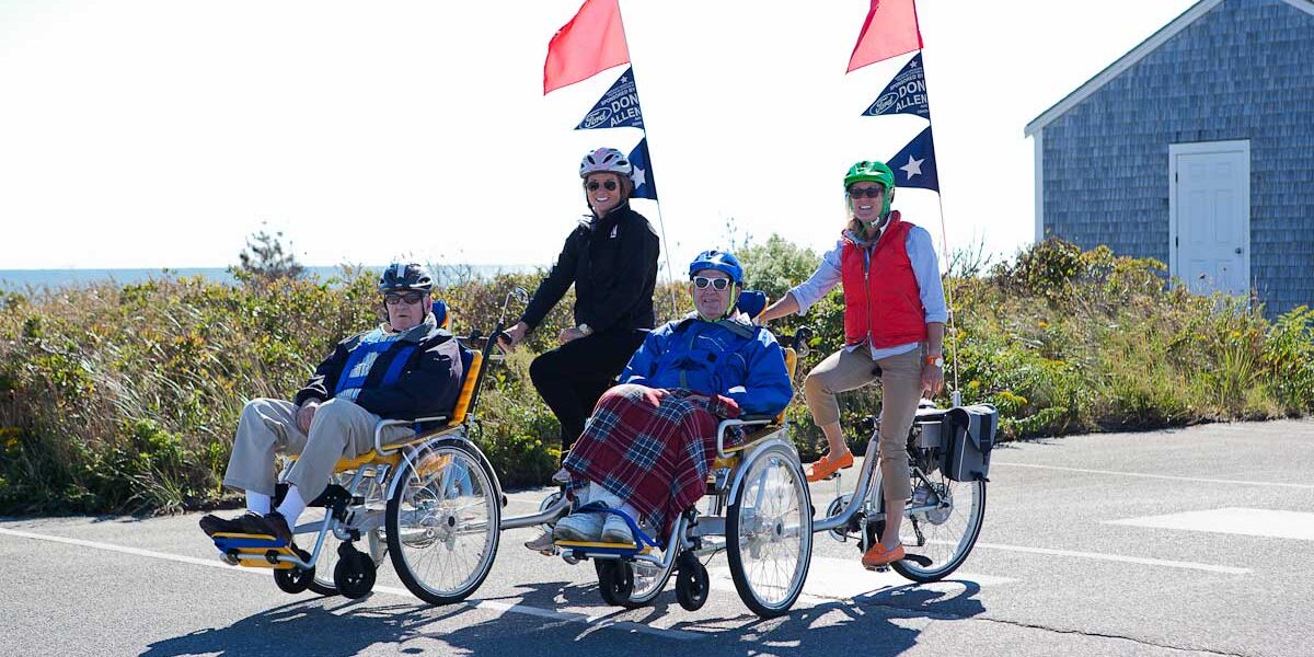 Four adults using wheelchair bikes.