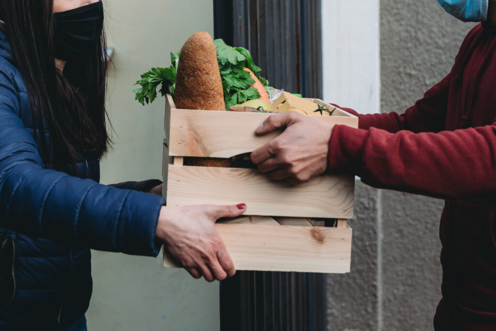 Delivery man is delivering fruits, vegetables and groceries to a woman