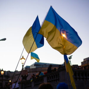 A group of people holding Ukrainian flags in front of a building