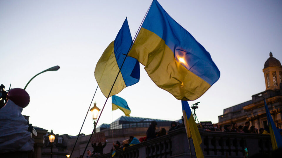 A group of people holding Ukrainian flags in front of a building