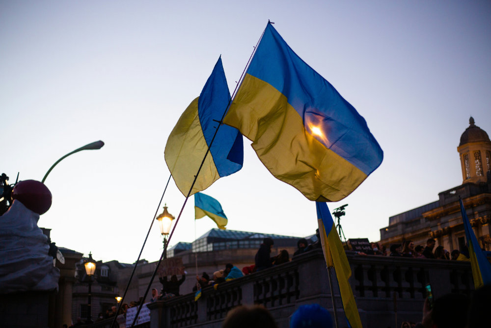 A group of people holding Ukrainian flags in front of a building